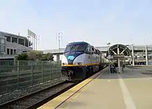 A diesel locomotive at a surface-level railway station