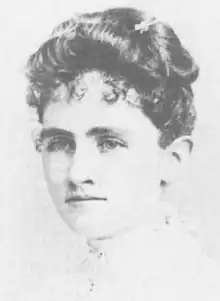 A young white woman with dark curled hair in an updo