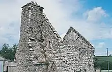 An image of the missing roof of Carswell Medieval House on a sunny day, standing relatively derelict