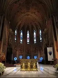 A closer view of the rear of the church interior seen above, with a golden altar in the foreground