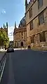 Catte Street looking South towards the Radcliffe Camera from outside Hertford College and the Bodleian Library which is the foreground. There is a car on the street.