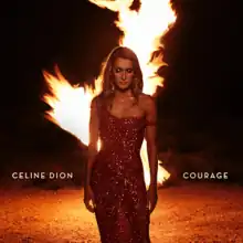 An image of a woman, in a dress, standing in front of a fire blaze