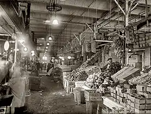 Produce section at the Center Market in Washington, D.C. On the left is Louis P. Gatti's fruit and vegetable stand.