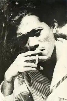 A portrait of a man looking forward while smoking a cigarette