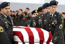 A casket team from the 1st Special Forces Group carry the flag-draped casket of Sergeant 1st Class Nathan R. Chapman on January 8, 2002, at Seattle-Tacoma International Airport.