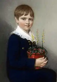 Three quarter length portrait of seated boy smiling and looking at the viewer;  he has straight mid-brown hair and wears dark clothes with a large frilly white collar;  in his lap he holds a pot of flowering plants