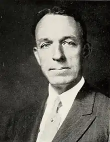 A man wearing jacket and tie, posed for a photograph
