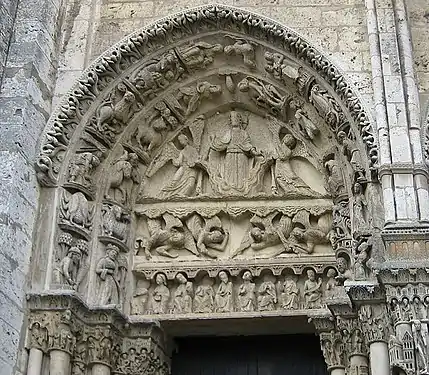 West portal, tympanum of left door. It depicts Christ on a cloud, supported by two angels, above a row of figures representing the labours of the months and signs of the Zodiac