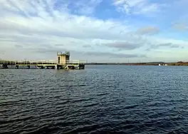 A large lake with a jetty and a water tower