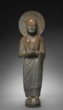 Monk holding cylinder-shaped object. Monk is depicted with aura-like shape around the head