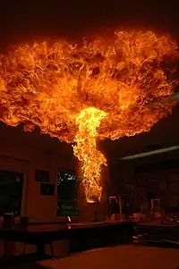 The plume rises and spreads against the ceiling