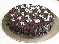 A chocolate cake garnished with violets