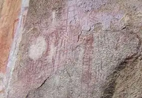 A picture of various red markings on a stone wall.