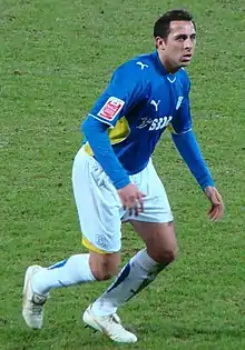 A footballer wearing a blue and white kit