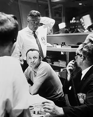 Gathering around his desk in the control room