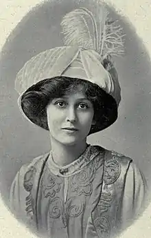 A young white woman wearing a large plumed hat, in an oval frame.