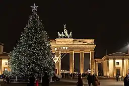 Christmas tree and menorah with Brandenburg Gate in background