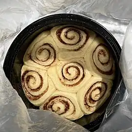 The rolls have expanded even more, to fill the entire pan from edge to edge with no gaps.  The dough looks dry but is pale and soft