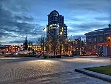 A picture of a recreational ground with a sculpture of a salmon and a building in the background.