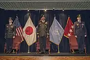 UNC and UNC-R officers pictured during a 2018 UNC-R change of command ceremony. In the background are the flags of the United States, Japan, Australia, United Nations, as well as General Brooks' position standard.