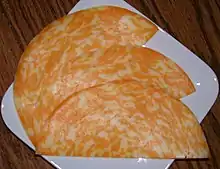 Three half-circle slices of cheese arranged on a plate