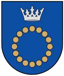 A coat of arms depicting a circle for which the boundary is itself made up of beige circles all under a silver crown on a blue background