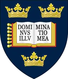 A shield displaying a coat of arms; on a dark blue background, an open book displays the words "Dominus illuminatio mea", with two gold crowns above and one below