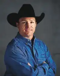 man in black cowboy hat and blue denim shirt