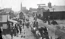 Colorado Boulevard in 1890, then named Colorado Street. Looking east to Marengo Avenue. Horse-drawn wagons displaying America flags, maybe a July 4 parade.