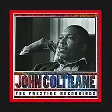 A black and white photo of a thirtysomething African-American man daydreaming. The box title design is in shades of red and blue with the words "JOHN COLTRANE. THE PRESTIGE RECORDINGS" and the cover has a narrow red border rounded by a wider black border.