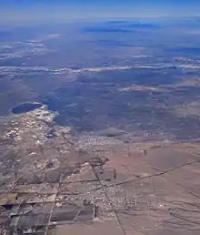 In this aerial photograph looking over Columbus, New Mexico (foreground), Puerto Palomas is in the center, with its near edge defining the international border.
