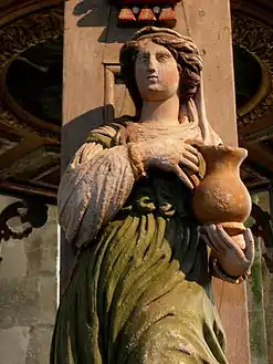 A wood carving, an allegory for "Temperance", on one of the five pillars supporting the baldachin.