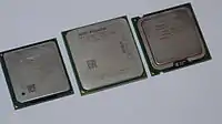 Side-by-side comparison of AMD (center) and Intel (sides) integrated heatspreaders (IHS) common on their microprocessors.
