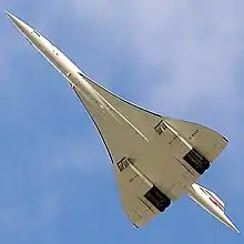 A view from below of an aeroplane in flight, with a slender fuselage and swept back wings.
