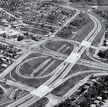 An aerial view of a freeway interchange, in black and white