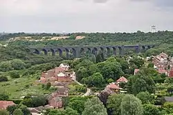 A long viaduct in the distance, with trees in the foreground