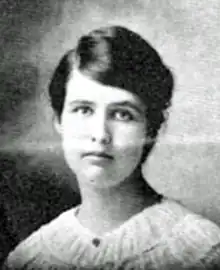 A young white woman with dark hair parted on the side