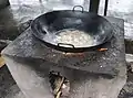 A wok on an outdoor wood stove