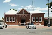 The exterior of the Coonabarabran post office from the street. It is red brick with white detailing.