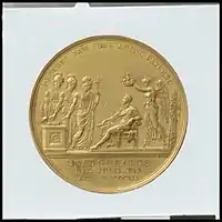 medal of a king, seated on a chair being crowned as figures offer homage
