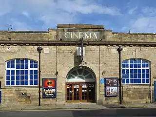 A Yorkshire stone building, with large windows either side of a central porch, with four wooden doors. "Cinema" is written above the porch in gold lettering.