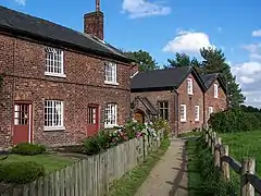 row of Victorian brick cottages with gardens