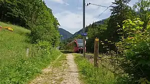 Red train on single-track at platform