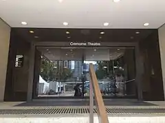 Entrance to Cremorne Theatre and Gallery. CBD high rise buildings directly opposite across the Brisbane River, are reflected in the Theatre's glass doors.