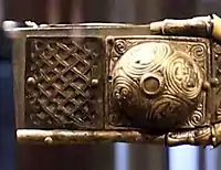 Left hand arm of the cross, with boss, and openwork panel described as comparable to inserts on the Moylough Belt-Shrine.