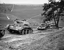 A Cruiser IV tank in the foreground, followed by several others.