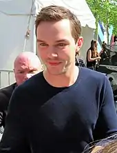 A caucasian man in a blue sweatshirt smiling at the camera.