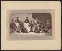 Dōst Moḥammad Khan seated slightly to the right of center in this photograph. To Dōst Moḥammad's right, the first figure in a white chapan (overcoat) is his son and successor Sher ʻAlī Khān (1825–1879), who ruled Afghanistan from 1863 to 1879. Abd al-Raḥmān Khān (c. 1844 – 1901), the grandson of Dōst Mohammad and future “Iron Amir” of Afghanistan, is on Dōst Moḥammad's far left.