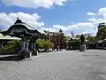 View of Temizuya, bronze statue of Toyotomi Hideyoshi, and the 2nd torii gate, seen upon passing through the Shinshu Ueda Ukimurazakura (torii gate), located in front of the Hokoku Shrine. The on the far right is the edge of the Banquet Hall.