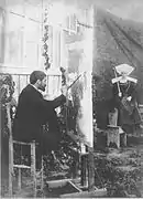 Photograph of Dagnan at his easel while his wife Walter poses in Breton costume. Taken in 1886